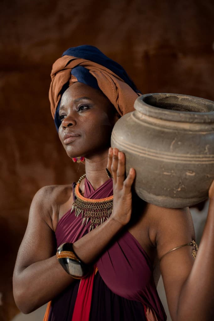 African woman carrying traditional clay pot