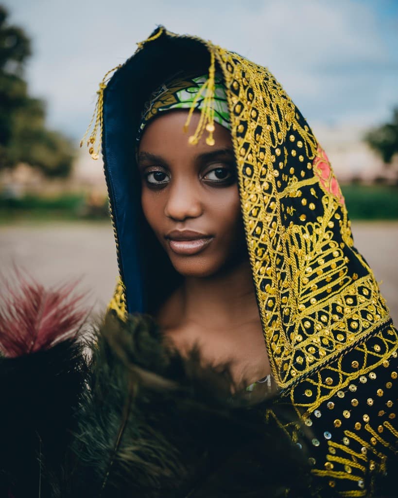 Young woman in black and gold embroidered traditional cape